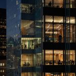 A striking view of the 599 Lexington Avenue skyscraper in Midtown Manhattan, showcasing its sleek glass facade and modern architecture, illuminated against the evening New York City skyline.