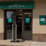 A closed M&T Bank branch on Hertel Avenue in Buffalo, with a sign indicating the closure and directing customers to a nearby location.