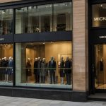 A closed Michael Kors storefront on Buchanan Street in Glasgow, with covered windows and no visible signage, captured on a busy shopping day.