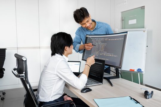 Engineers reviewing code on a monitor: Test a Public-Record API Thoroughly Before You Build On It